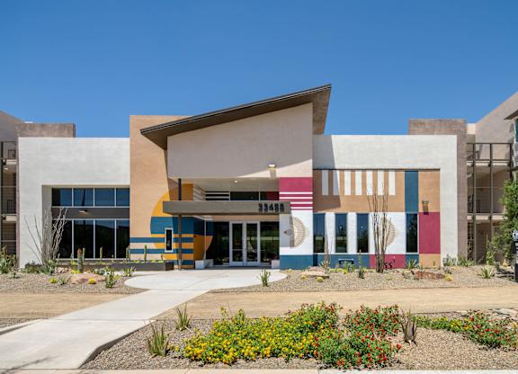 A modern building with a colorful facade and a clear blue sky in the background.