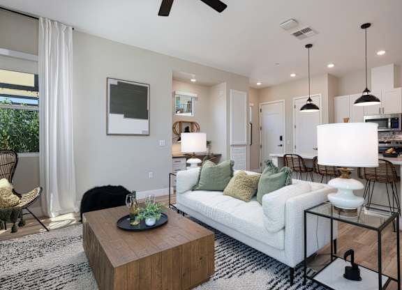 A modern living room with a white sofa and a wooden coffee table.