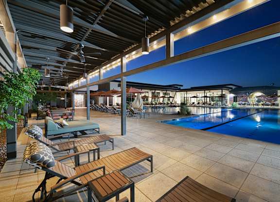 A pool area with a table and chairs.