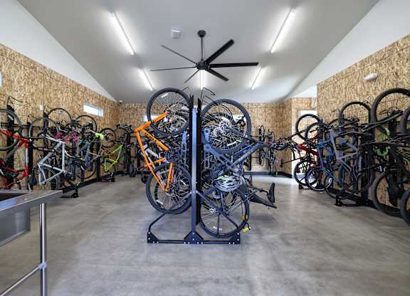 A room full of bicycles with a ceiling fan.