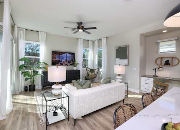 A living room with a white couch and a glass table.