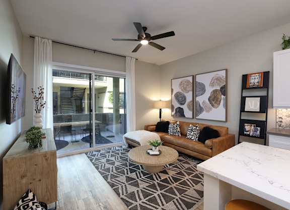 A living room with a couch, a coffee table, and a ceiling fan.