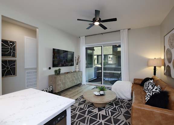 A living room with a brown couch and a white coffee table.