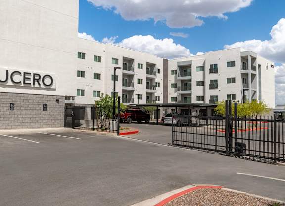 The Lucero building has a black gate and a red brick border.