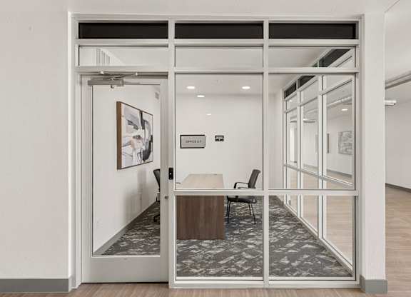 A glass door with a white frame leads to a room with a table and chairs.