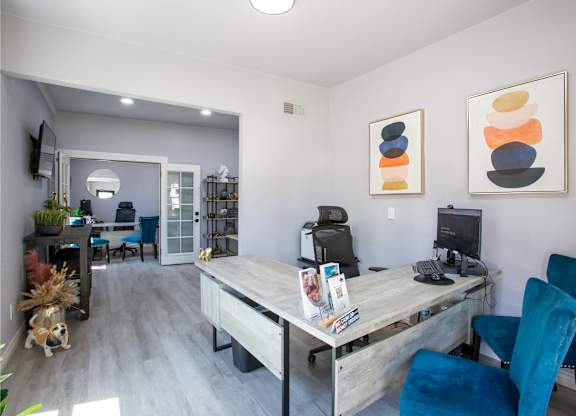 A room with a desk and chairs.