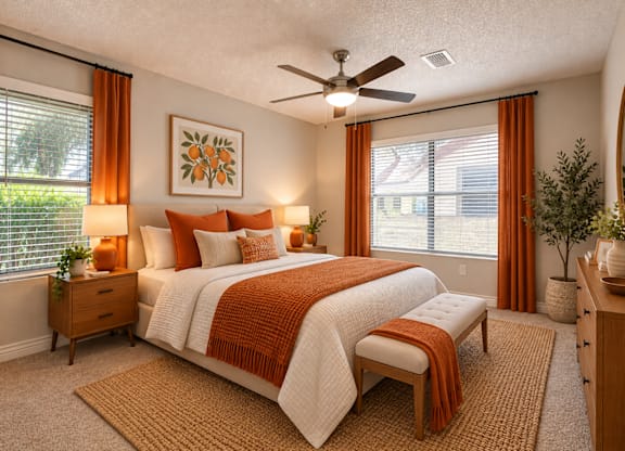 A bedroom with a bed, nightstands, and a ceiling fan.