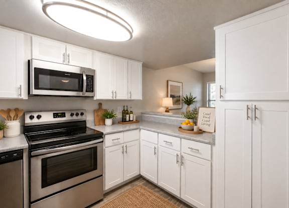 A kitchen with white cabinets and a stainless steel oven.