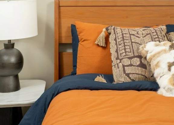 A bed with a blue pillow and a dog on it.