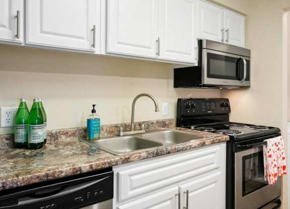 A kitchen with white cabinets and a granite countertop.