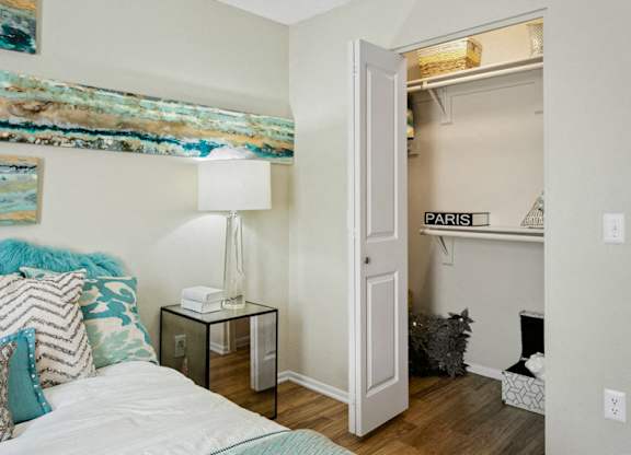A bedroom with a bed, a lamp, and a painting on the wall.