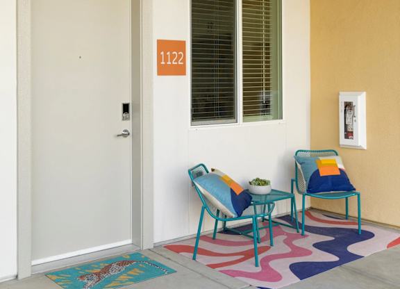 A white door with a number 1122 on the wall next to a window.