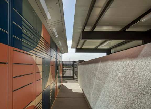 A long hallway with a white wall on the right and a wall with orange and blue on the left.