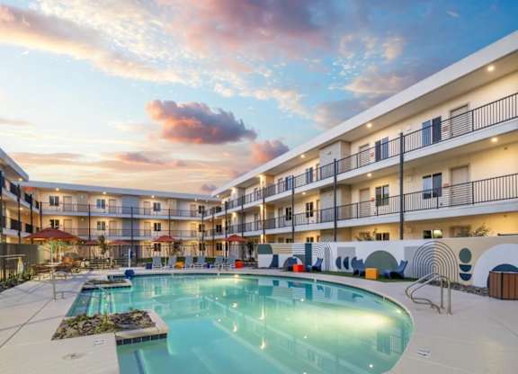 A large swimming pool in the middle of a courtyard surrounded by apartment buildings.