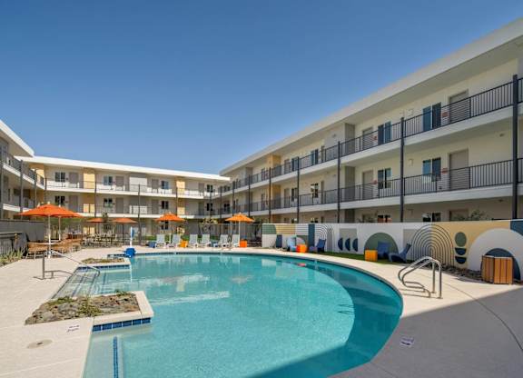 A large swimming pool in front of apartment buildings.