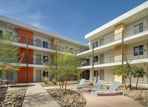 A modern building with orange and white balconies.