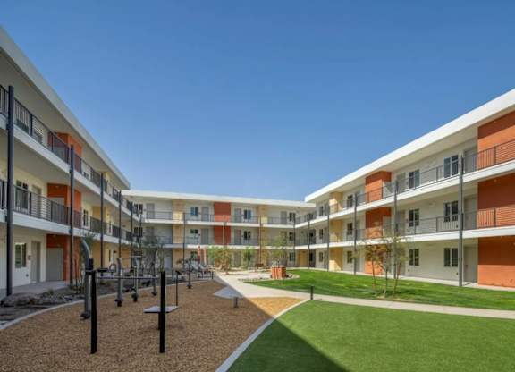 A sunny day at a modern apartment complex with a playground.