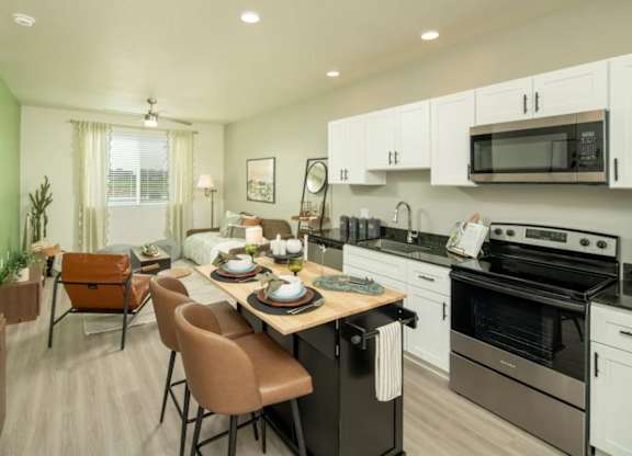 A kitchen with a table set for a meal.