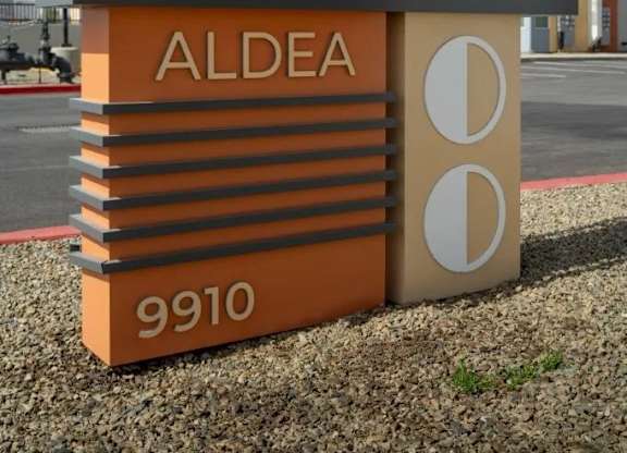 A sign for a place called "Caboama ALDEA" with the number 9910 on it.