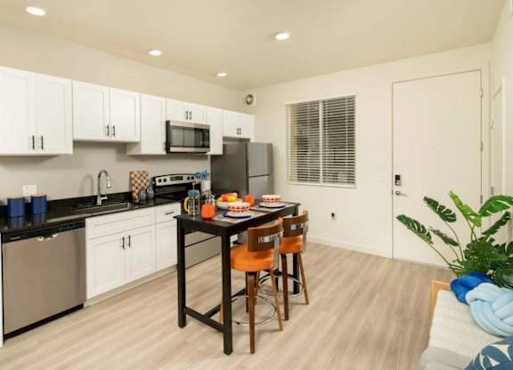 A kitchen with white cabinets and a black countertop.