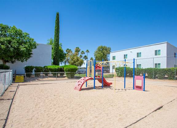 A playground with a red slide and a blue climbing frame.