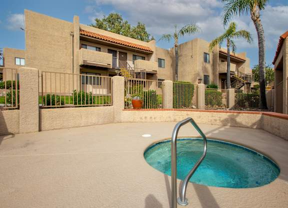 A small pool in a courtyard surrounded by houses.
