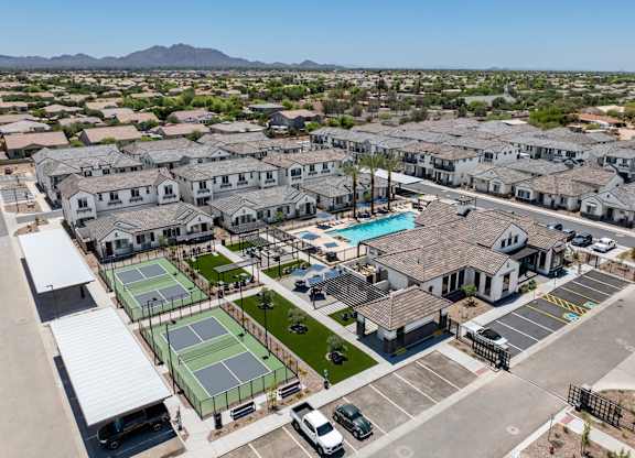 A large residential complex with tennis courts and a swimming pool.