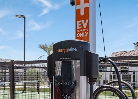A ChargePoint EV charging station is located next to a tennis court.