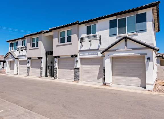 A row of houses with white garage doors.