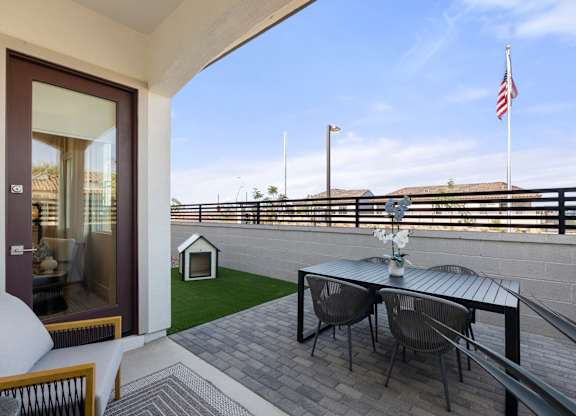 A patio with a table and chairs overlooking a balcony.