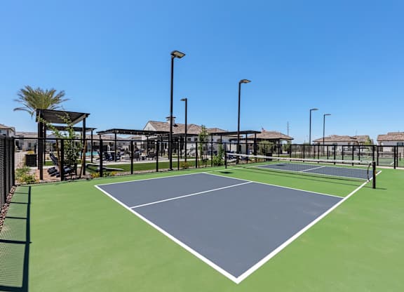 A tennis court with a green surface and white lines.
