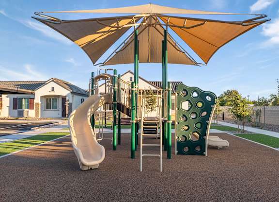 A playground with a slide, swings, and a canopy.