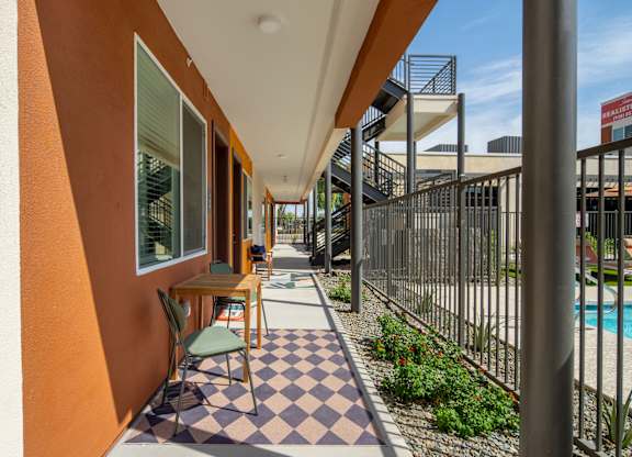 A patio with a checkered floor and a table with chairs.
