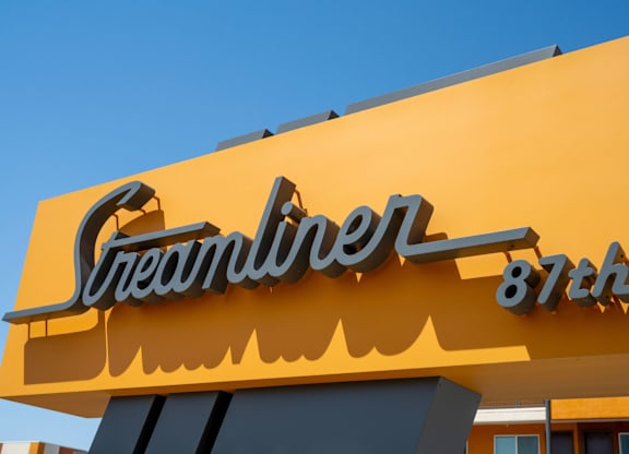 A yellow sign with the word "Streamliner" and the number 87th.