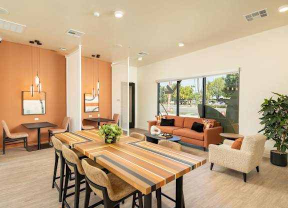 A modern dining room with a long wooden table and chairs.