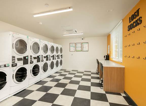 A laundromat with a row of washers and dryers.