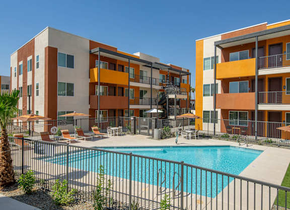 A large apartment complex with a pool in the courtyard.