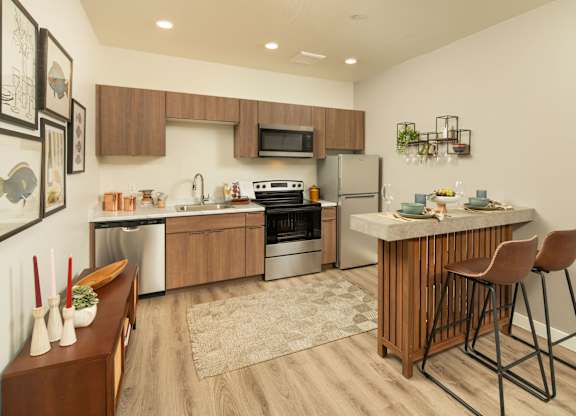 A modern kitchen with a wooden island and bar stools.