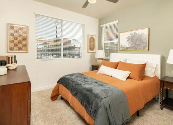 A bedroom with a bed, nightstand, and window.