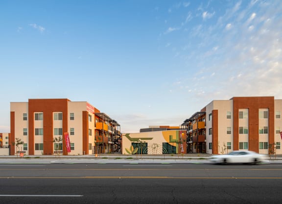 A modern building with a yellow and orange facade is captured in a blurred motion.