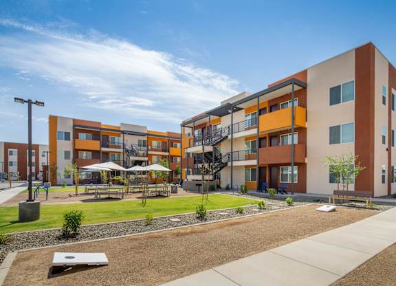 A modern apartment complex with a playground in the front.