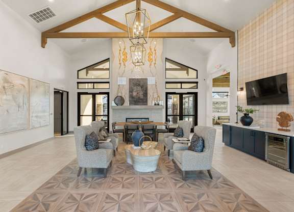 A modern living room with a large rug and a chandelier.