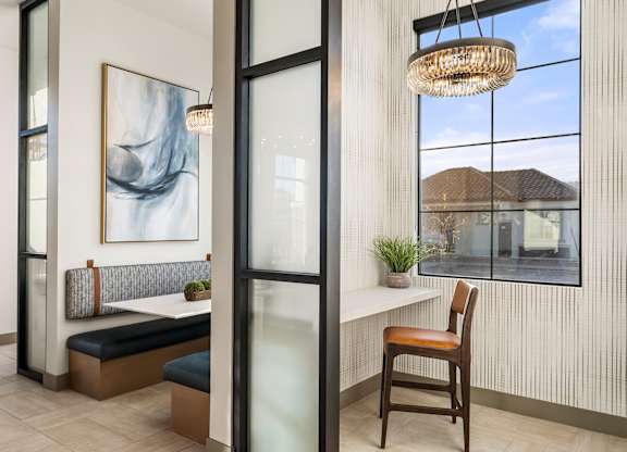 A room with a bench, a table, and a chair.