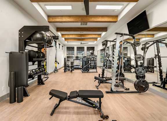 A gym with a variety of equipment including weights and machines.