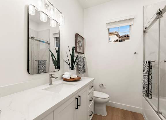 A bathroom with a white counter top and a toilet.