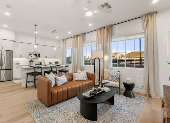 A modern living room with a brown leather sofa and a black coffee table.