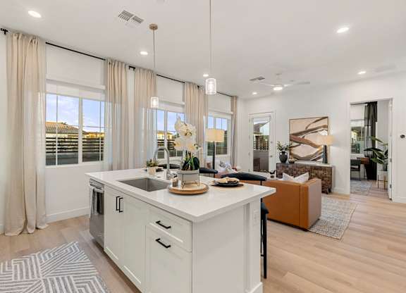 A modern kitchen with a large island and a view of the outdoors.