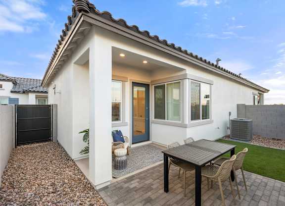A small white house with a patio and a table.