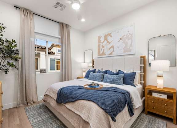 A bedroom with a large bed and a mirror on the wall.