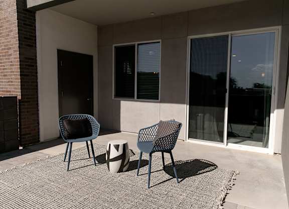 A patio with two chairs and a table.